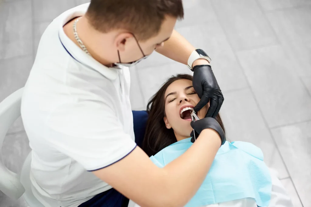 Emergency biological dentist performing extraction